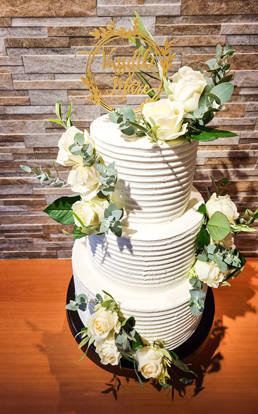 Weiße dreistöckige Hochzeitstorte mit weißen Rosen
